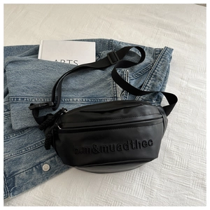 Detail of black leather waist bag with textured embroidery and adjustable nylon strap