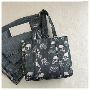 Overhead view of large tote bag with skull and floral print on denim jacket