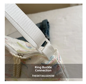 Detailed macro view of embroidered fabric texture and nylon strap attachment on the tote