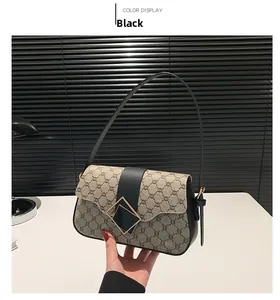 Détail du sac bandoulière vintage avec boucle métallique géométrique dorée et bordure noire