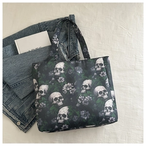 Detail of skull and floral print on high-capacity black tote bag with denim jacket