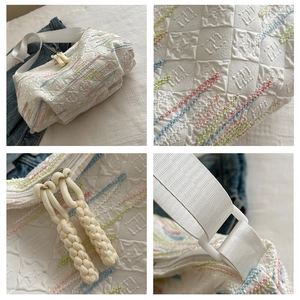 Close-up showing colorful quilted embroidery details and zipper on the white tote bag