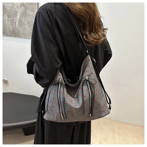 Detail der grauen Segeltuchtasche mit roten Punkten und silbernen Reißverschlüssen