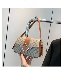 Vue détaillée du sac bandoulière vintage marron avec monogramme et fermoir en métal