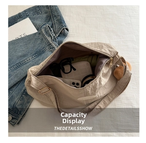 Detail showing spacious interior of beige pleated tote bag with umbrella and accessories
