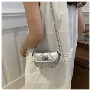 Détail d'un mini sac argenté matelassé avec bandoulière chaîne et fermoir métallique chic