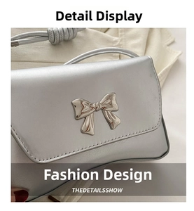 Détail du sac à main argenté métallisé avec boucle décorative élégante en nœud