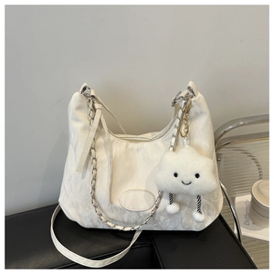 Close-up of white crescent bag with pleated texture, chain detail and cloud charm