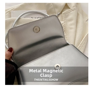 Gros plan sur le fermoir magnétique argenté d'un sac baguette métallisé chic