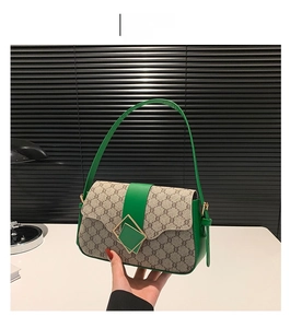 Vue détaillée du cuir vert et de la toile monogramme de ce sac à bandoulière chic