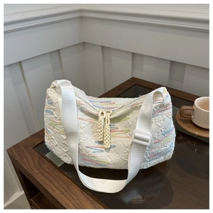 Detail of white tote bag with rainbow embroidery lines and textured woven fabric
