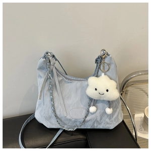 Detail of light blue crossbody bag with marble texture and plush cloud accessory