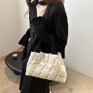 Sac fourre-tout matelassé blanc minimaliste avec poignées noires dans un cadre lifestyle