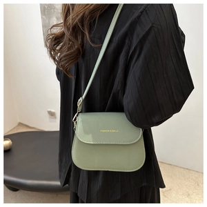 Detail of light green faux leather crossbody bag with gold Fashion & Bags lettering