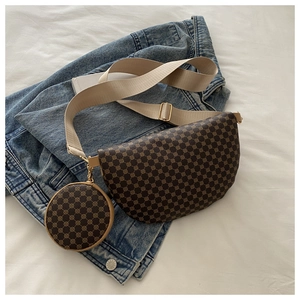 Close-up of vintage brown patterned crossbody bag with a round coin purse on denim background