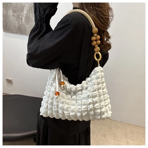 Détail du sac blanc en seersucker avec bandoulière unique en perles de bois