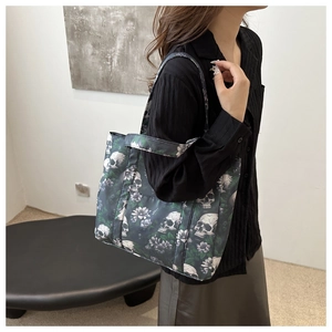 Detail of large shoulder tote bag featuring realistic white skull and green floral prints