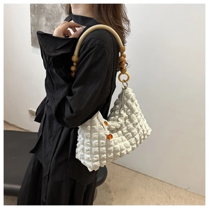 Détail du sac à bandoulière blanc plissé avec poignée en perles de bois et cordon