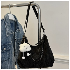 Detail of black textured tote bag with metal chain accents and cute cloud charm