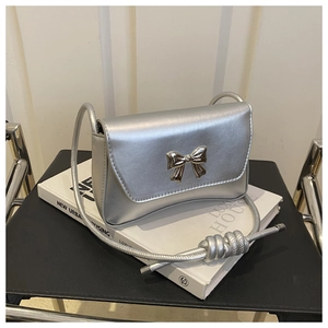 Détail du nœud métallique argenté et de la bandoulière nouée sur ce sac chic