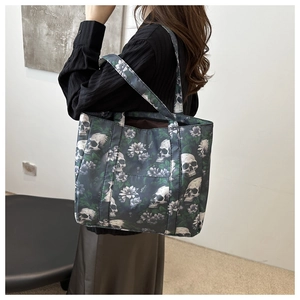 Detail of large tote bag with skull and floral print on dark green nylon fabric