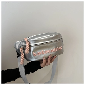 Close-up of metallic silver sling bag with pink embroidered letters and woven zipper pulls
