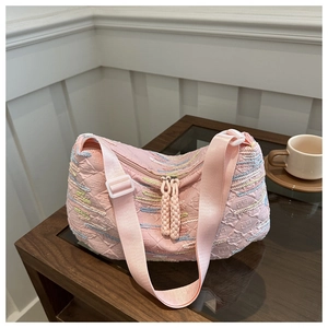 Detail of pink embroidered nylon crossbody bag with textured fabric and dual zipper pulls