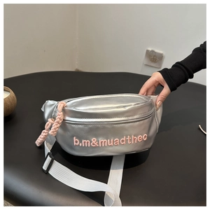 Detail of silver metallic waist bag featuring pink embroidered letters and woven rope puller