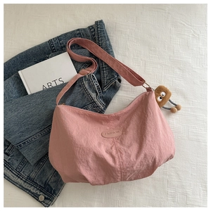 Pink nylon hobo bag featuring fashion leather label and funny brown plush charm