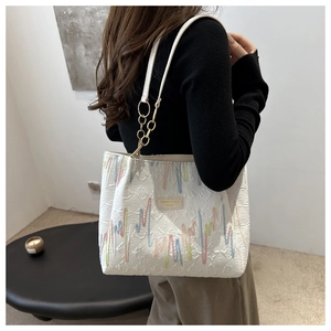 Détail du sac cabas matelassé blanc avec broderie colorée et chaîne dorée