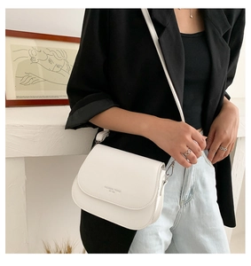 Close-up of white PU leather saddle bag featuring Fashion Trend lettering on flap