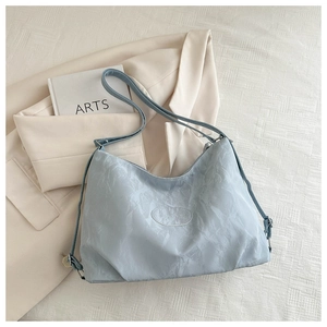 Detail of light blue tote bag showing unique cloud-like wrinkled texture and logo patch