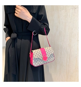 Détail d'un sac à bandoulière chic avec motif monogramme et accents cuir magenta vif