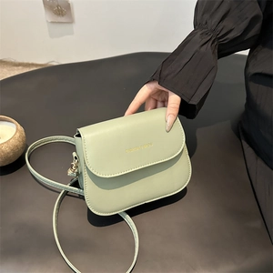 Minimalist sage green leather saddle bag for women with gold lettering and slim strap