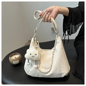 Detail of white marble pattern shoulder bag with silver chain and plush cloud charm