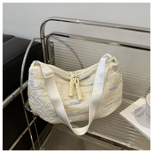 Detail view of the white embossed canvas bag with colorful embroidery and rope zipper puller