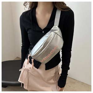 Détail du sac argenté avec broderie rose am&muadtheo et bandoulière en textile gris