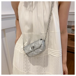 Détail du mini sac bandoulière matelassé argenté avec chaîne et fermoir rotatif en métal