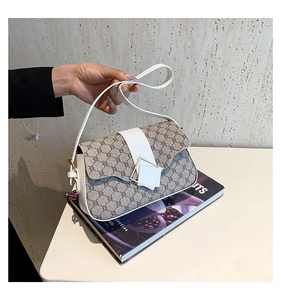 Détail du sac à bandoulière en toile avec motif géométrique et finition cuir