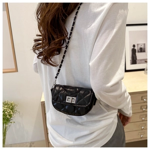 Détail du mini sac bandoulière matelassé noir avec chaîne argentée sur le mannequin