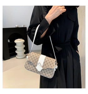 Détail du sac à bandoulière monogramme rétro avec finitions en cuir blanc et boucle métal