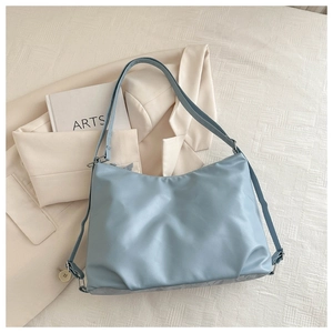 Close-up of light blue waterproof nylon tote bag with adjustable shoulder strap and hardware