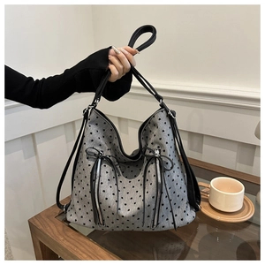 Detail of grey heart pattern tote bag with black bow and metal zipper decorations