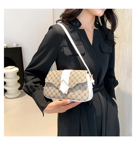 Détail du sac en toile monogrammée avec garniture en cuir blanc et boucle dorée chic