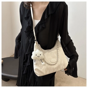 Detail of white pleated crescent bag with silver chain and plush cloud charm on model