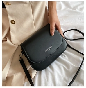 Close-up of black matte leather saddle bag featuring silver Fashion Trend 1996 text