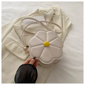 Detail of white flower-shaped crossbody bag with quilted petals and yellow center