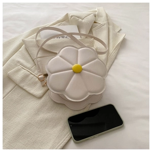 Detail of flower-shaped cream shoulder bag with yellow buckle on a beige blazer