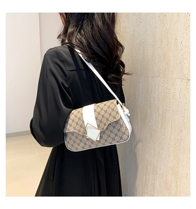 Détail du sac bandoulière tendance avec tissu monogramme marron et cuir blanc