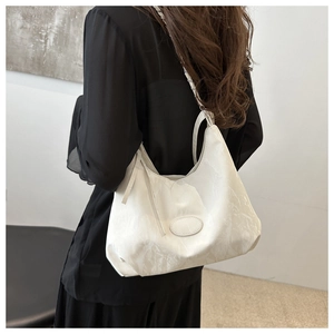 Detail of white marble textured tote bag featuring silver chain strap and leather patch